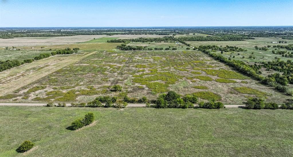 0 County Road 4604, Commerce, TX 75428 Expansive acreage featuring cleared level terrain, mature tree clusters, and direct road frontage