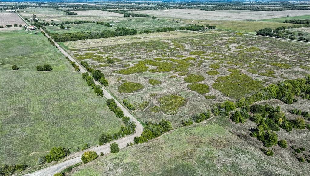 0 County Road 4604, Commerce, TX 75428 Expansive acreage featuring open meadow terrain, clusters of mature trees, and direct access to a paved thoroughfare