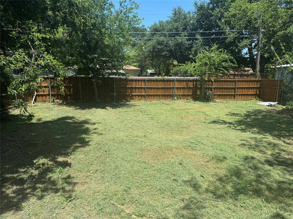 1123 Hansboro Avenue, Dallas, TX 75224 Expansive backyard featuring a fenced perimeter and mature trees