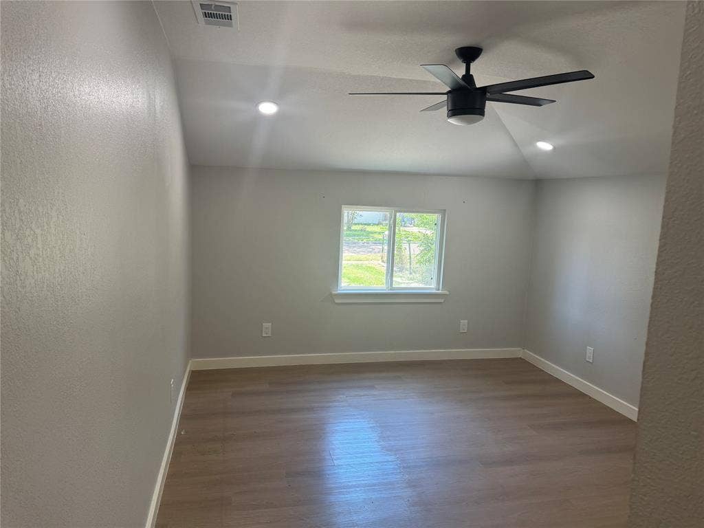 1123 Hansboro Avenue, Dallas, TX 75224 Room featuring a vaulted ceiling, wood-finish flooring, recessed lighting, and a matte black ceiling fan