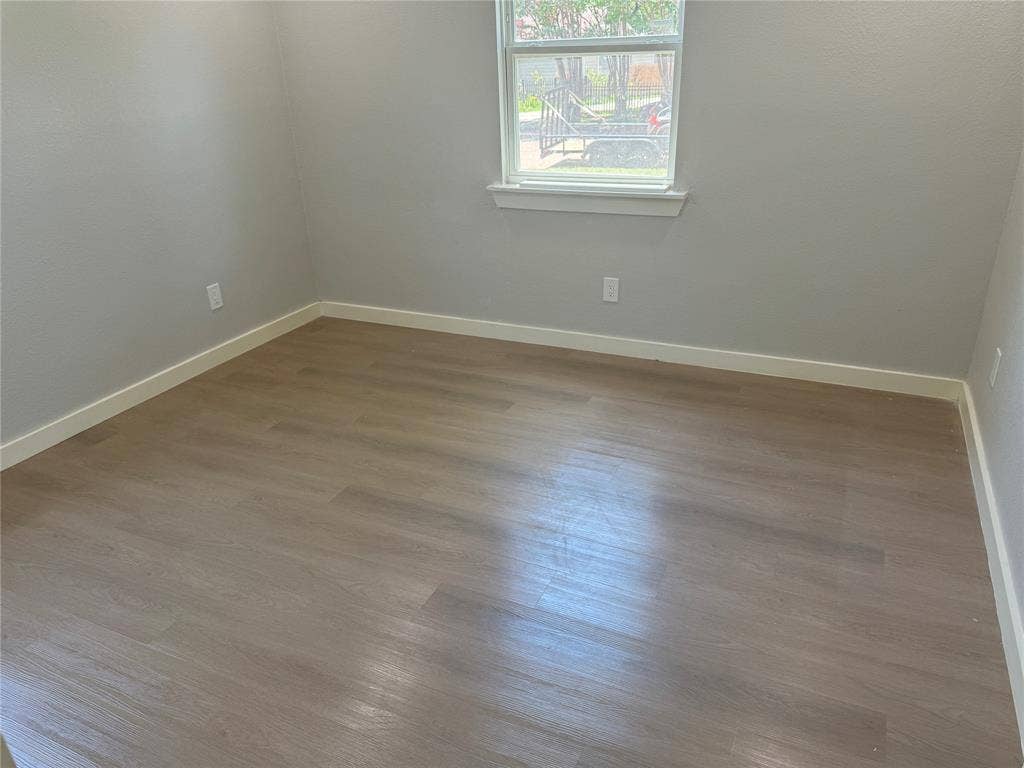 1123 Hansboro Avenue, Dallas, TX 75224 Room featuring wood-finish flooring, neutral paint palette, and a single-pane window with a sill