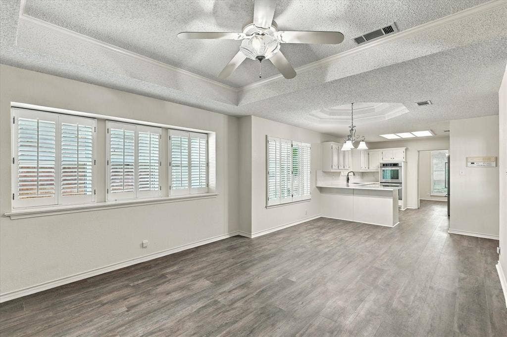 210 Santa Fe Trail, Waxahachie, TX 75165 Tray ceilings with integrated lighting, wood-finish flooring, plantation shutters, and recessed kitchen cabinetry