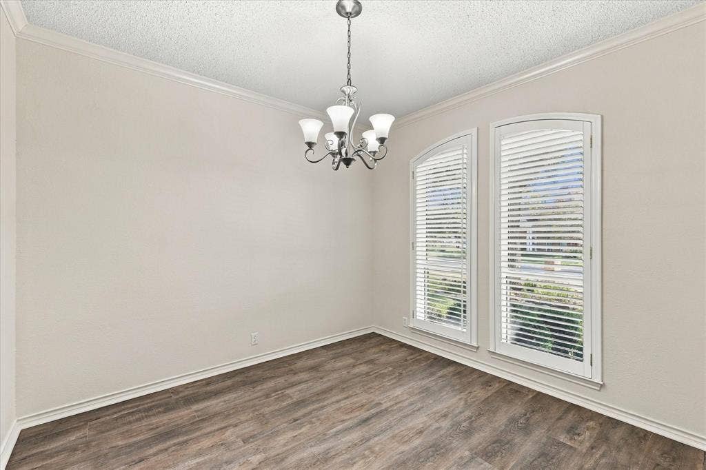 210 Santa Fe Trail, Waxahachie, TX 75165 Room featuring wood-finish flooring, crown molding, a five-arm metal chandelier, and dual arched windows with white shutters