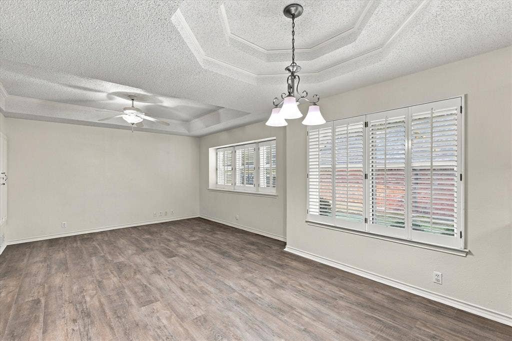 210 Santa Fe Trail, Waxahachie, TX 75165 Tray ceiling featuring a central tiered design, wood-finish flooring, plantation shutters, and a multi-light chandelier
