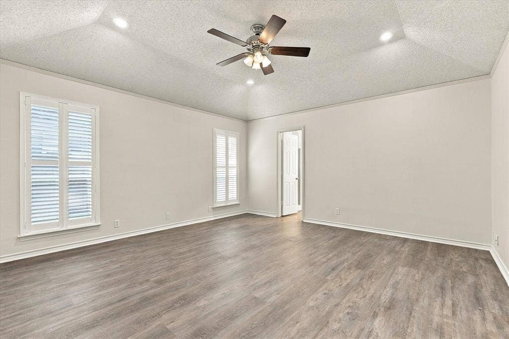 210 Santa Fe Trail, Waxahachie, TX 75165 Vaulted ceiling featuring a central multi-blade ceiling fan, recessed lighting, wood-finish flooring, and windows with white plantation-style shutters