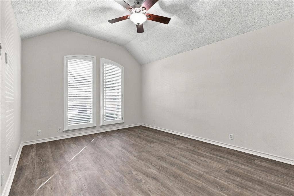 210 Santa Fe Trail, Waxahachie, TX 75165 Vaulted ceiling featuring a central ceiling fan with integrated lighting, wood-finish flooring, and arched-top windows