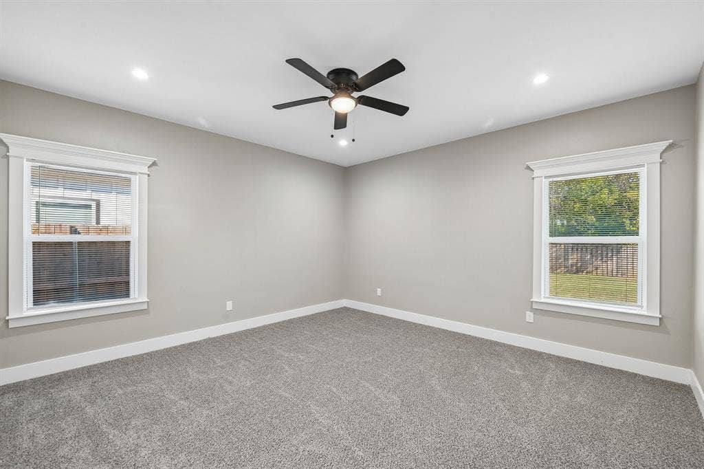 1221 S Rockwall Avenue, Terrell, TX 75160 Neutral-toned interior featuring wall-to-wall carpeting, recessed lighting, a ceiling fan with integrated lighting, and dual windows with crown-molding trim