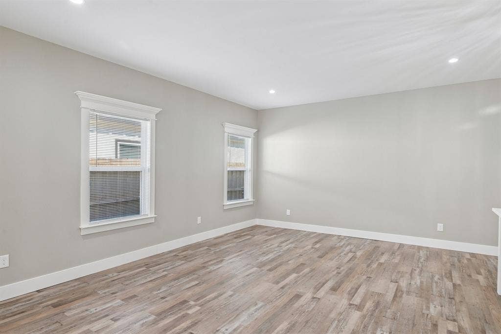 1221 S Rockwall Avenue, Terrell, TX 75160 Neutral-toned walls, wood-finish flooring, recessed lighting, and double-hung windows with decorative crown molding trim