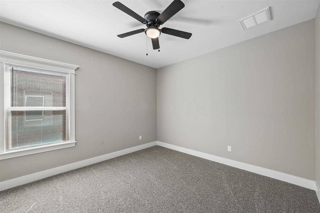 1221 S Rockwall Avenue, Terrell, TX 75160 Neutral interior with carpeting, window with decorative trim, and a ceiling-mounted fan with integrated lighting