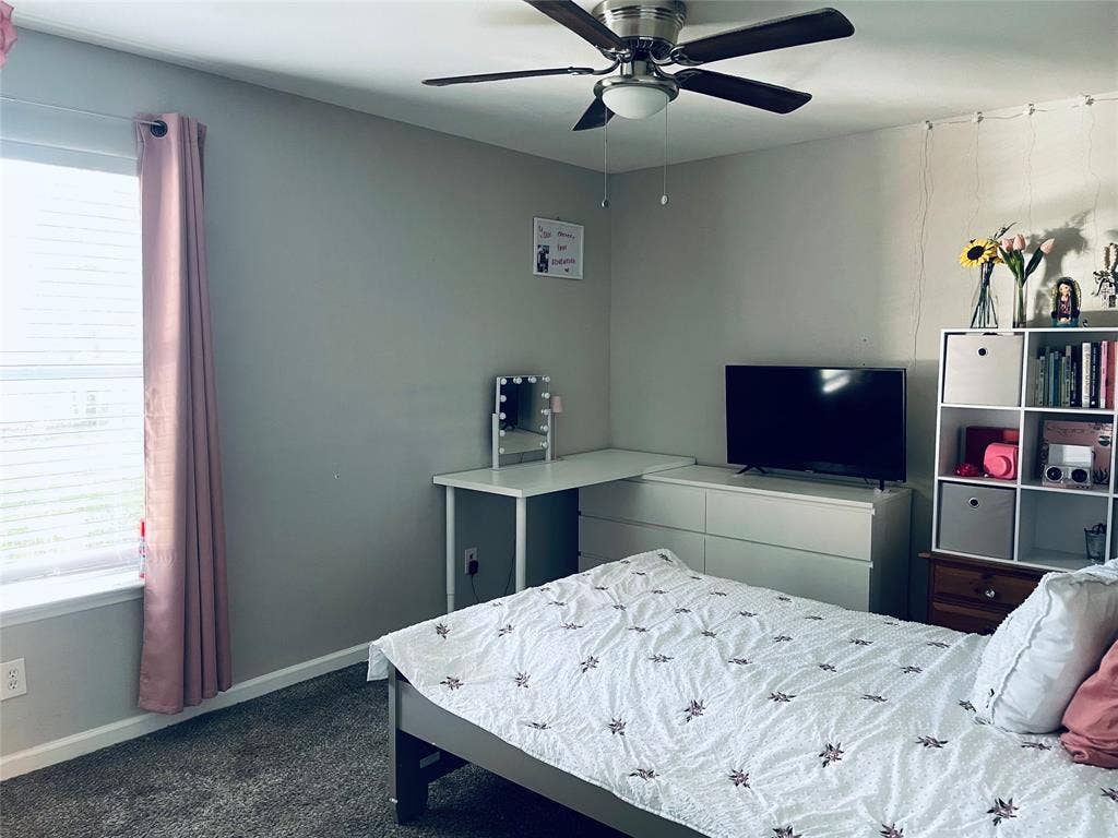 706 E High Street, Terrell, TX 75160 Neutral-toned interior featuring wall-to-wall carpeting, a multi-blade ceiling fan with integrated lighting, and a window with horizontal blinds