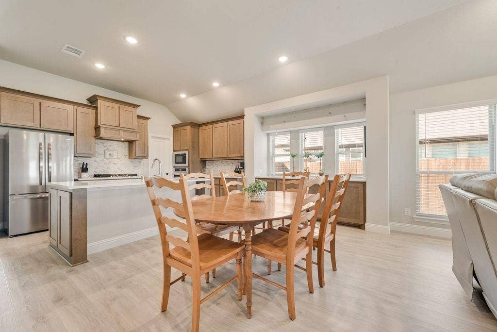 208 Shady Bank Way, Nevada, TX 75173 Kitchen featuring wood cabinetry, stainless steel appliances, a central island with quartz countertop, recessed lighting, and wood-finish flooring