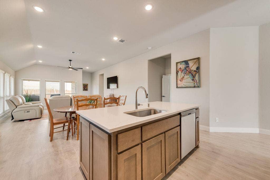 208 Shady Bank Way, Nevada, TX 75173 Kitchen island featuring light-toned cabinetry, quartz countertops, an undermount stainless steel sink, and recessed lighting throughout the room