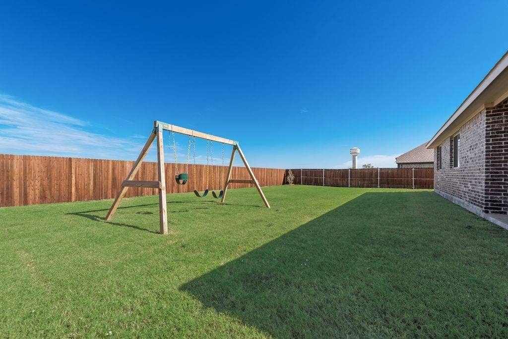 208 Shady Bank Way, Nevada, TX 75173 Fenced backyard featuring a manicured lawn and brick exterior wall