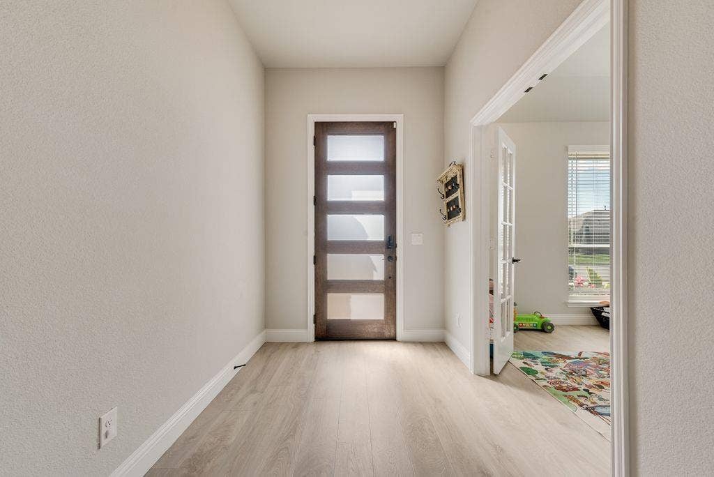 208 Shady Bank Way, Nevada, TX 75173 Entryway featuring wood-finish flooring, a contemporary door with five horizontal frosted-glass panels, and a French door with glass panes