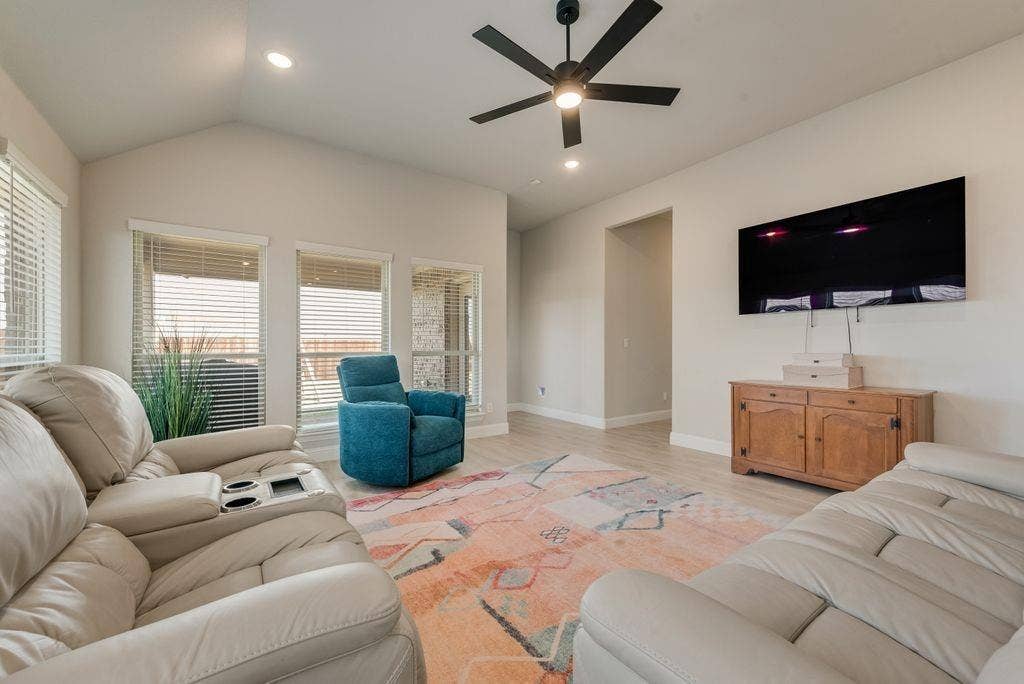 208 Shady Bank Way, Nevada, TX 75173 Vaulted ceiling, matte black ceiling fan, wood-finish flooring, and multiple windows with horizontal blinds