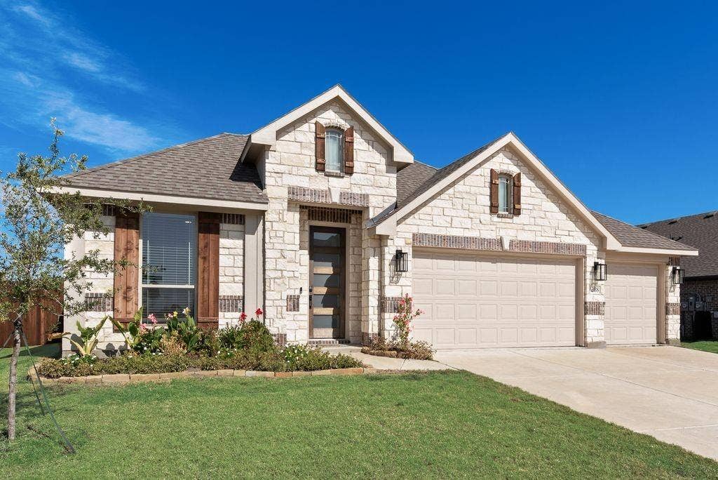 208 Shady Bank Way, Nevada, TX 75173 Stone facade exterior featuring wooden window shutters, a multi-car garage, and architectural gables