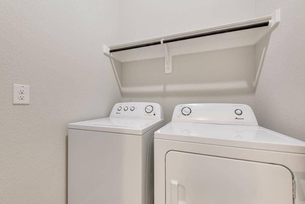 208 Shady Bank Way, Nevada, TX 75173 Laundry area featuring a top-load washer, front-load dryer, and an overhead built-in shelving unit with an integrated hanging rod