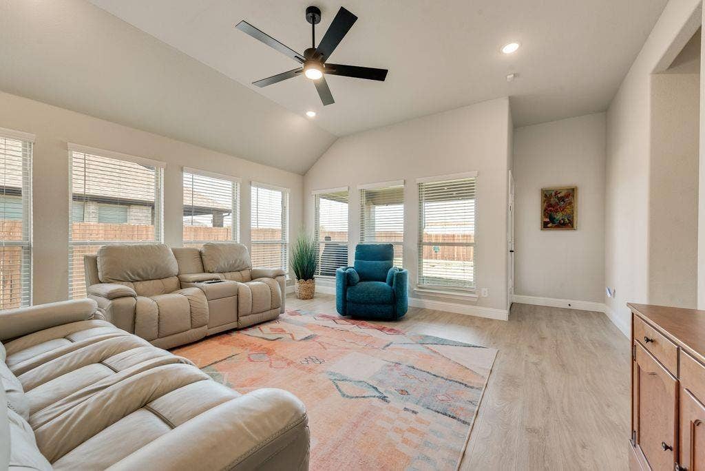 208 Shady Bank Way, Nevada, TX 75173 Vaulted ceilings, wood-finish flooring, six large windows, and a matte black ceiling fan with integrated lighting