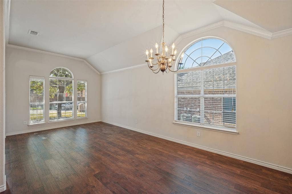 1021 Cherry Hill Lane, DeSoto, TX 75115 Vaulted ceilings, wood-finish flooring, oversized arched windows, and a multi-arm chandelier