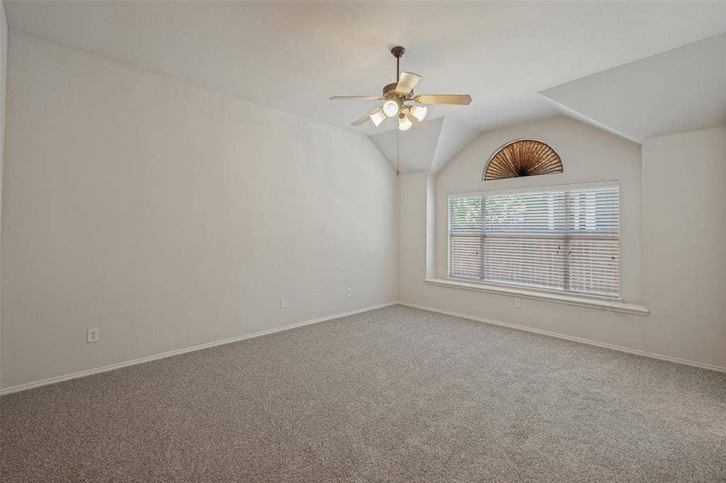 1021 Cherry Hill Lane, DeSoto, TX 75115 Vaulted ceilings featuring a multi-light ceiling fan and a decorative arched window with a built-in ledge