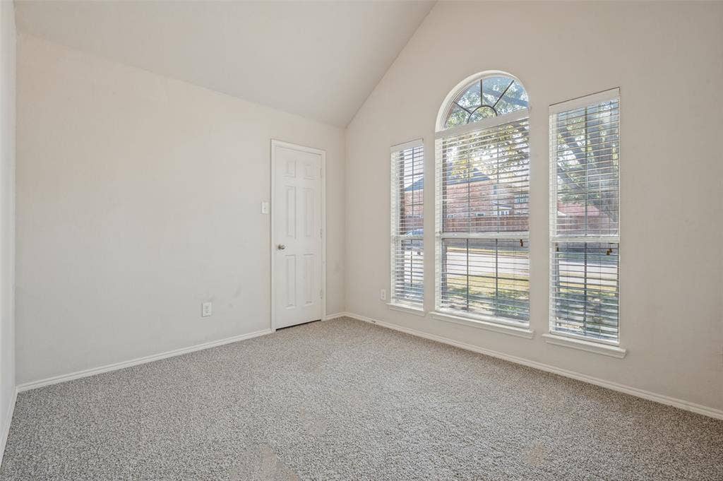 1021 Cherry Hill Lane, DeSoto, TX 75115 Vaulted ceilings, neutral carpeting, and a prominent arched window assembly with integrated blinds