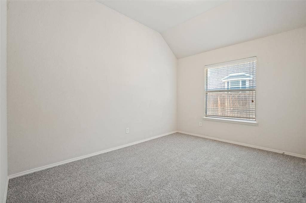 1021 Cherry Hill Lane, DeSoto, TX 75115 Vaulted ceiling, neutral wall tones, and wall-to-wall carpeting with a single window featuring horizontal blinds