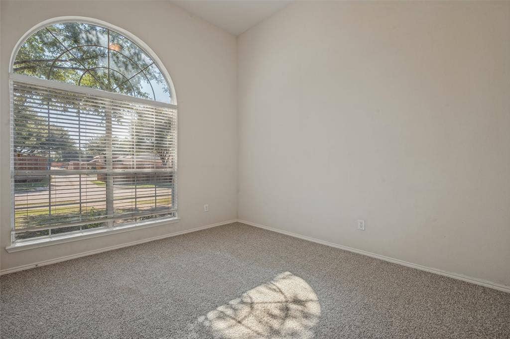 1021 Cherry Hill Lane, DeSoto, TX 75115 High-vaulted ceiling room featuring a large arched window and neutral carpeting