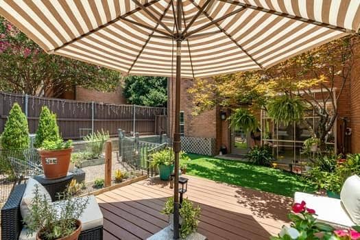 Composite deck featuring a brick exterior wall, screened-in enclosure, and perimeter privacy fencing
