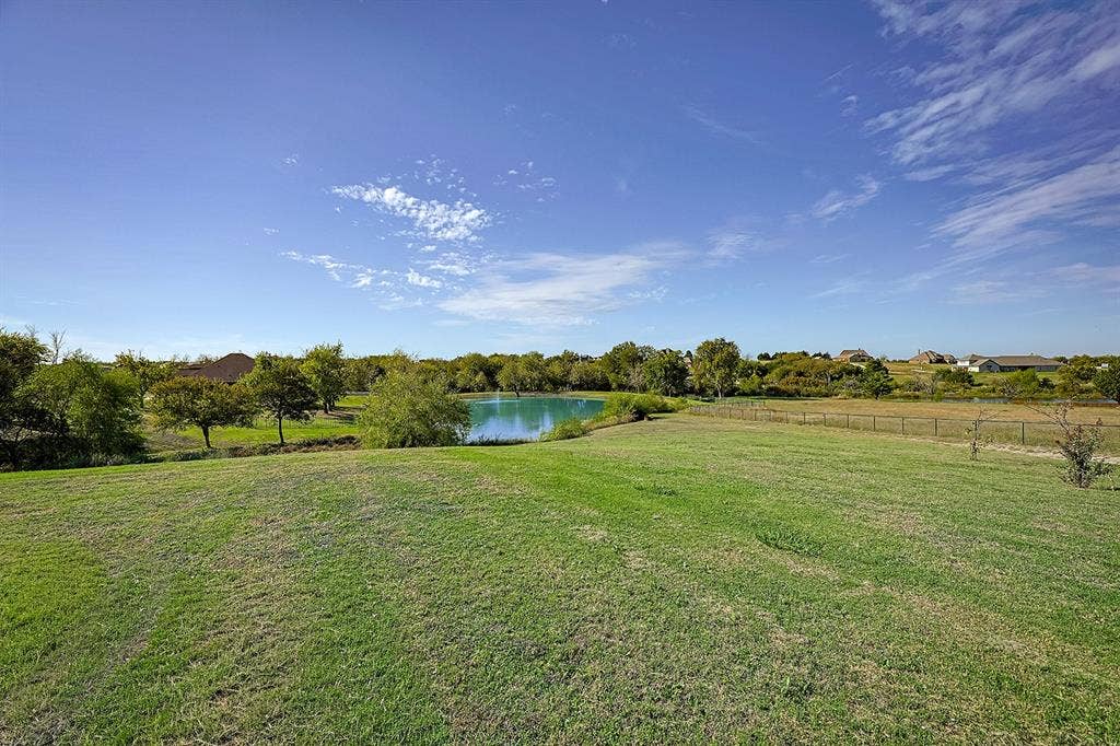 2828 Luke Drive, Farmersville, TX 75442 Expansive grounds featuring a manicured lawn, natural pond, mature trees, and perimeter fencing
