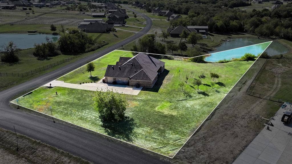 2828 Luke Drive, Farmersville, TX 75442 Aerial view of a residential property featuring a multi-pitched roofline, brick exterior, attached garage, expansive lot, and private pond access