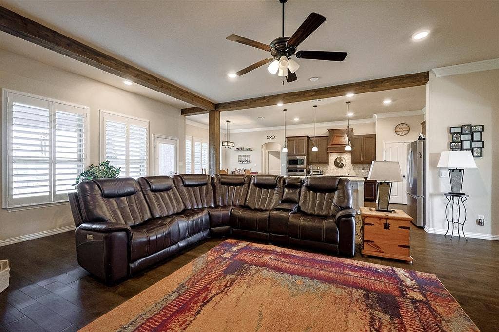 2828 Luke Drive, Farmersville, TX 75442 Open-concept interior featuring wood-finish flooring, decorative ceiling beams, plantation shutters, recessed lighting, and a kitchen island with pendant fixtures