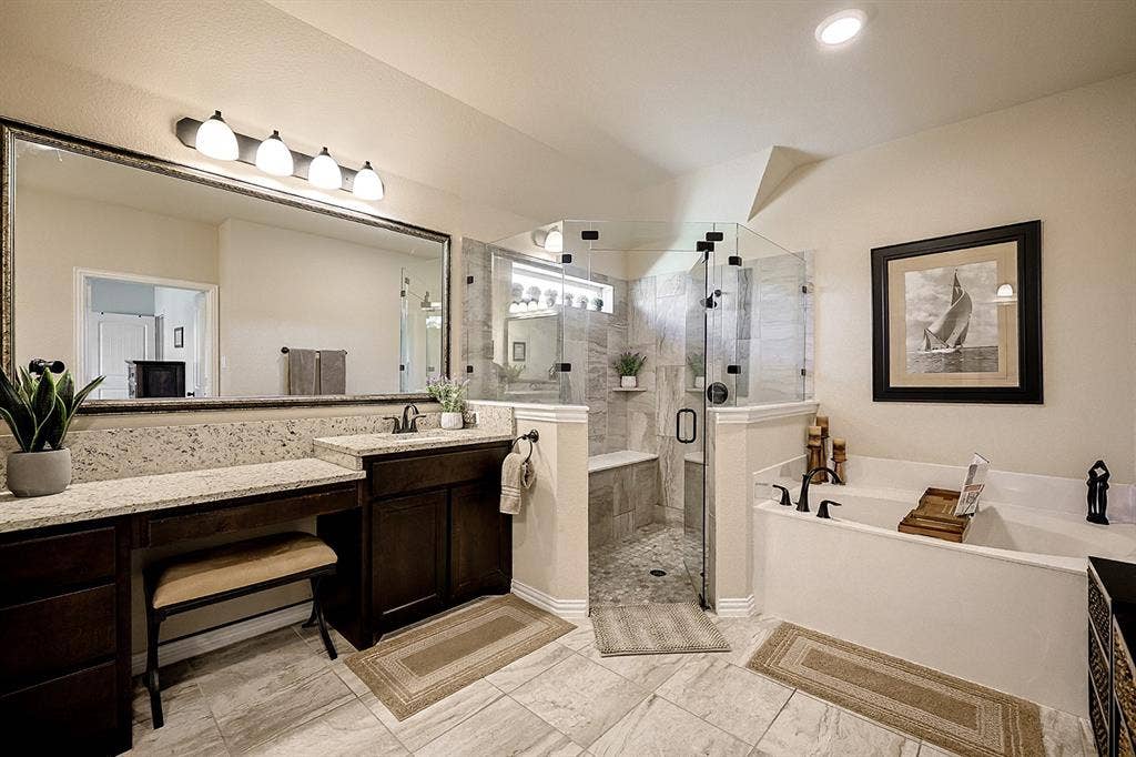 2828 Luke Drive, Farmersville, TX 75442 Bathroom featuring a dual-sink vanity with stone countertops, a frameless glass-enclosed shower with tile surround and built-in bench, a deep soaking tub, and tile flooring