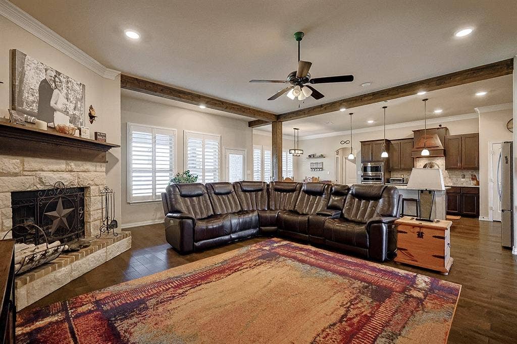 2828 Luke Drive, Farmersville, TX 75442 Stone fireplace with wooden mantel, wood-finish flooring, exposed wooden ceiling beams, recessed lighting, and wooden cabinetry