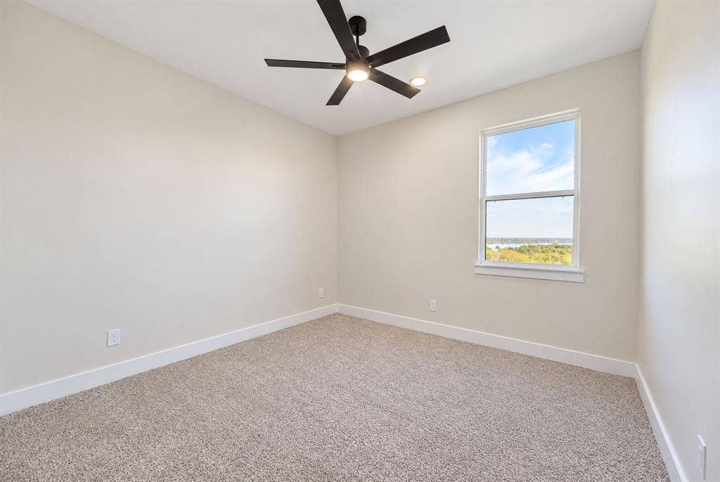 Neutral wall tones, wall-to-wall carpeting, single-hung window, and a matte black ceiling fan with integrated lighting
