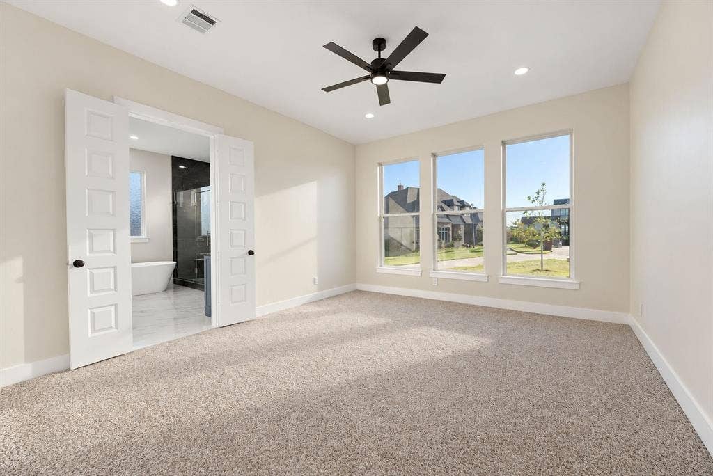 Neutral-toned carpeted flooring, matte black ceiling fan with integrated lighting, recessed lighting, and double doors featuring white paneling
