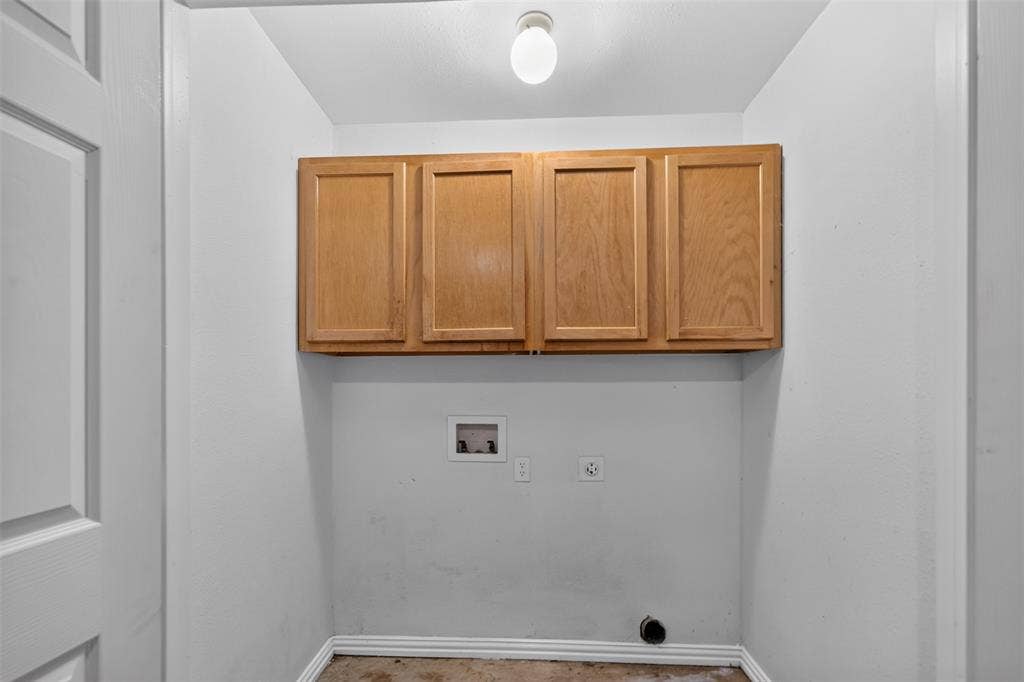 1708 Timber View Drive, Tyler, TX 75703 Utility area featuring wood-finish wall-mounted cabinetry, a recessed utility box, and integrated electrical and plumbing connections