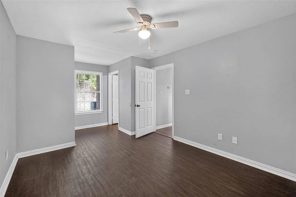 1708 Timber View Drive, Tyler, TX 75703 Interior space featuring neutral wall paint, wood-finish flooring, a ceiling fan with light fixture, and a multi-pane window