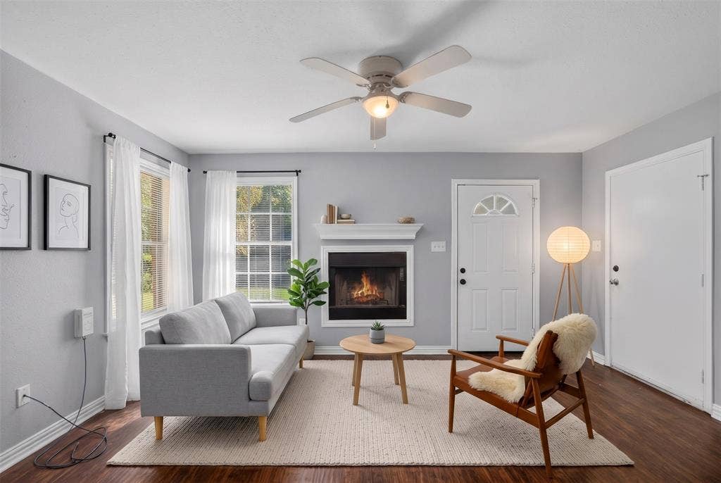 1708 Timber View Drive, Tyler, TX 75703 Fireplace with white mantel, wood-finish flooring, ceiling fan with integrated lighting, and multi-pane windows