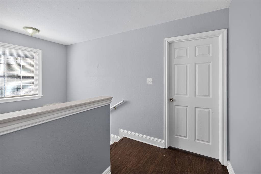 1708 Timber View Drive, Tyler, TX 75703 Six-panel interior door, wood-finish flooring, neutral wall paint, flush-mount light fixture, and window with blinds