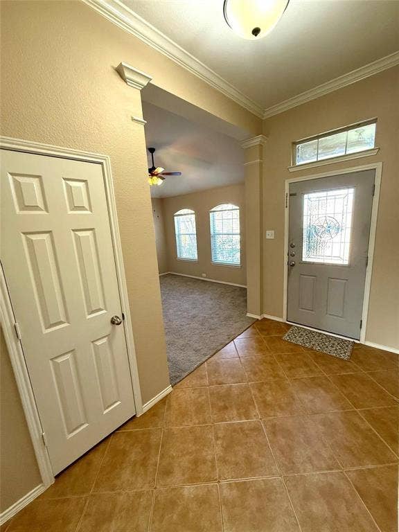 2111 Red River Road, Forney, TX 75126 Entryway featuring tile flooring, crown molding, a decorative glass-panel front door with transom window, and architectural column detailing