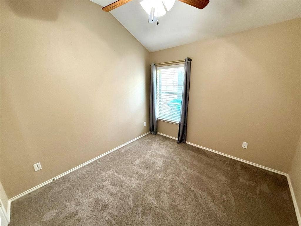 2111 Red River Road, Forney, TX 75126 Vaulted ceiling featuring a central multi-blade ceiling fan and wall-to-wall carpeting