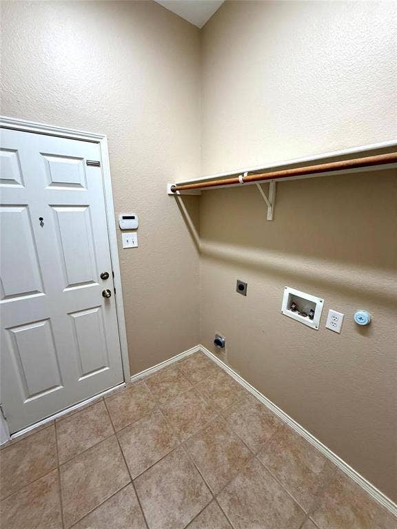 2111 Red River Road, Forney, TX 75126 Utility space featuring ceramic tile flooring, a six-panel door, and a built-in shelf with a clothes hanging rod