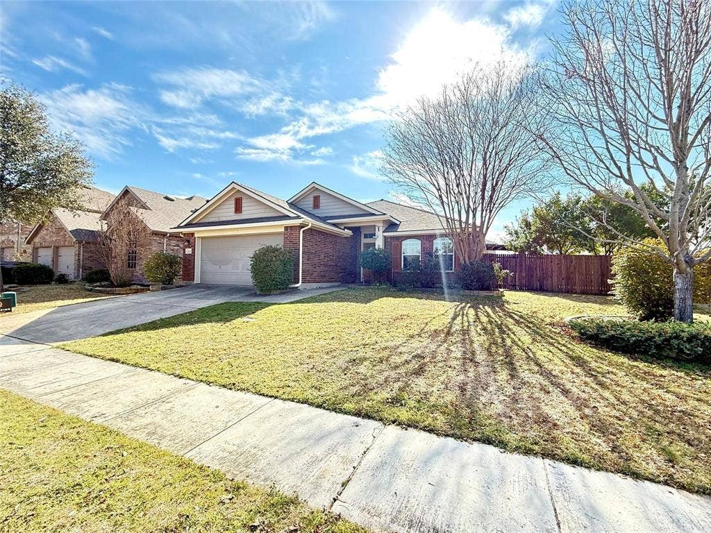 2111 Red River Road, Forney, TX 75126 Single-story residence featuring a brick and siding exterior, front-facing two-car garage, and a manicured lawn