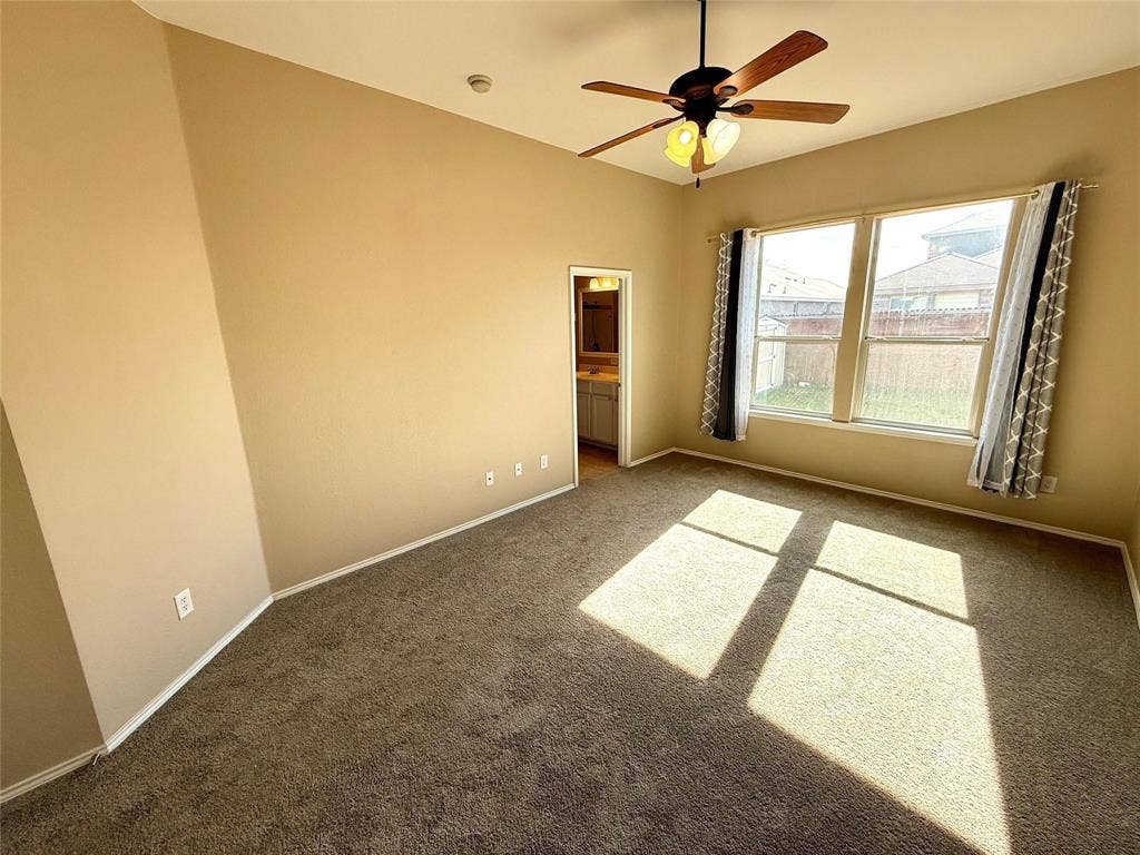 2111 Red River Road, Forney, TX 75126 High-ceilinged room featuring neutral carpeting, a central ceiling fan with multi-light fixture, and dual windows