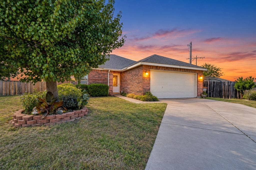 413 Bonnie Court, Anna, TX 75409 Brick exterior facade featuring a concrete driveway, two-car garage, and a stacked-stone landscape border