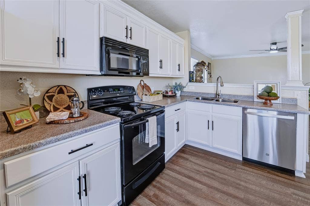 413 Bonnie Court, Anna, TX 75409 Kitchen featuring white shaker-style cabinetry with matte black hardware, stone-finish countertops, black electric range, stainless steel dishwasher, and wood-finish flooring