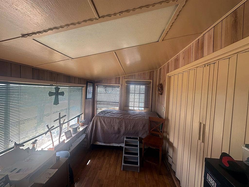 305 McKay Road, Burnet, TX 78611 Wood-finish paneling, wood-finish flooring, recessed lighting, and expansive windows featuring horizontal blinds