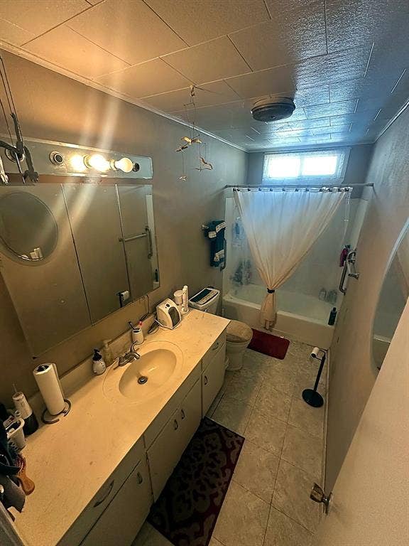 305 McKay Road, Burnet, TX 78611 Full-width vanity featuring a molded sink, expansive countertop, integrated medicine cabinet with mirrored doors, and tile flooring