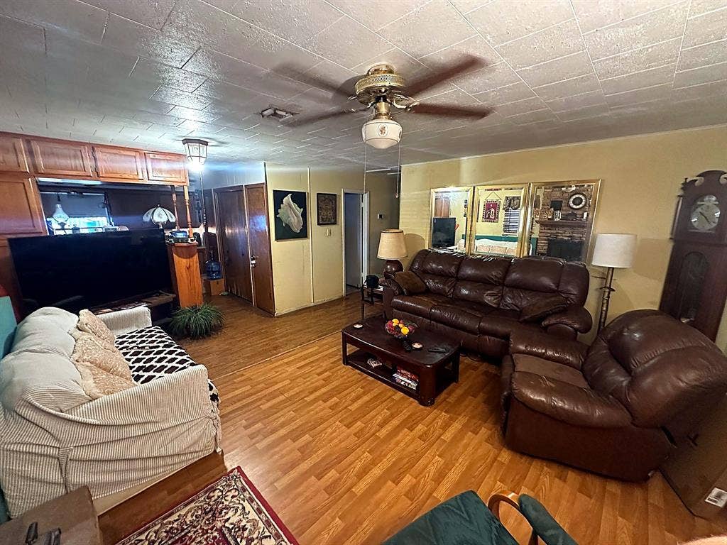 305 McKay Road, Burnet, TX 78611 Wood-finish flooring, ceiling fan with integrated lighting, mirrored wall accents, and built-in wood cabinetry