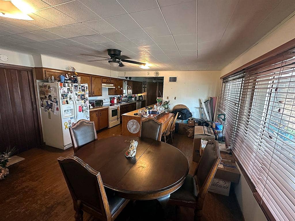 305 McKay Road, Burnet, TX 78611 Kitchen featuring wood cabinetry, a breakfast bar, wood-finish flooring, and horizontal window blinds